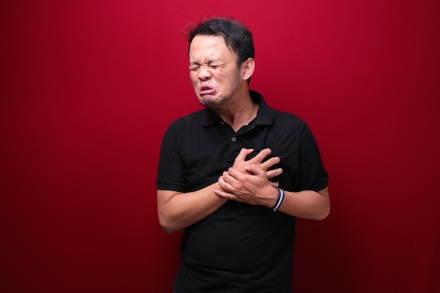 Heart attack or broken heart of young asian man with hurt emotion wear black shirt