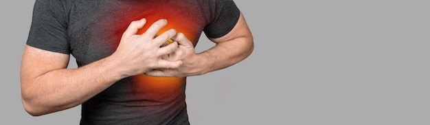 Heart attack Man clutching his chest from acute pain Heart attack symptom Severe heartache man suffering from chest pain having heart attack or painful cramps banner copy space