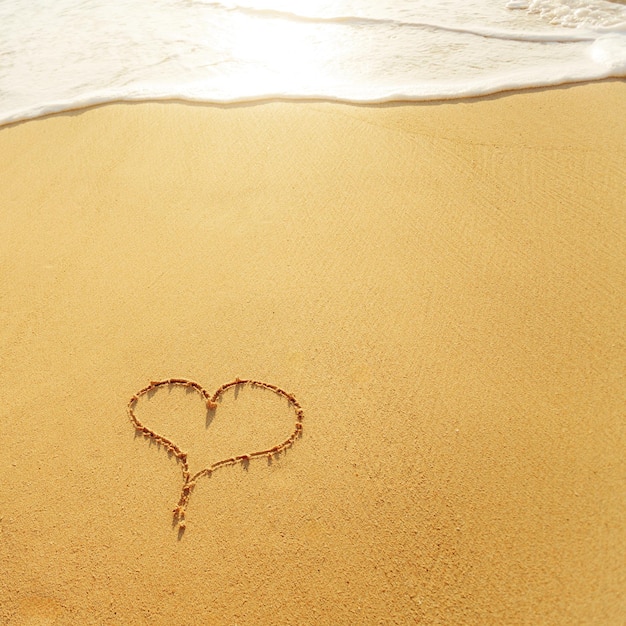 Heart on beach with sunset Copy space