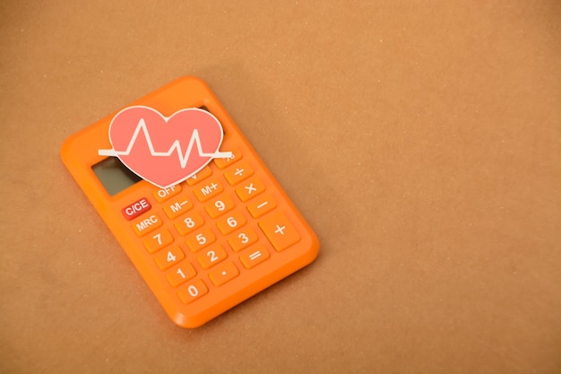 Heart beat and calculator Save money on health insurance drug cost and medical cost concepts