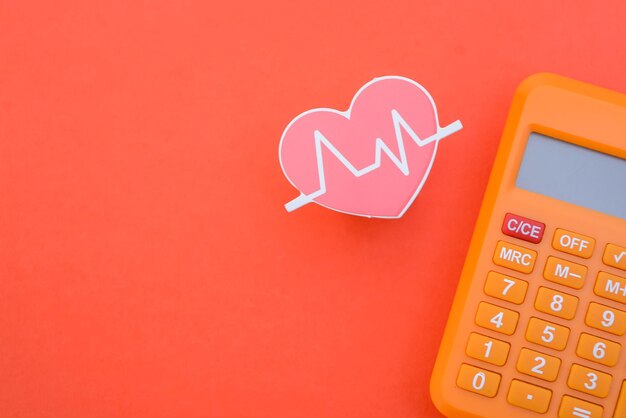 건강 비용이나 의료 비용을 추적하는 개념을 상징하는 심장 박동과 계산기