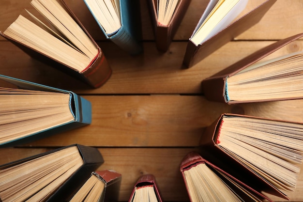 Heart of books on wooden background