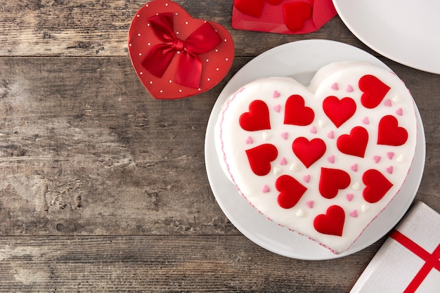 나무 테이블에 설탕 하트로 장식 된 성 발렌타인 데이 하트 케이크