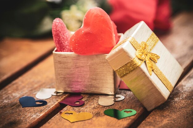 Photo heart candies and gummies on wooden background