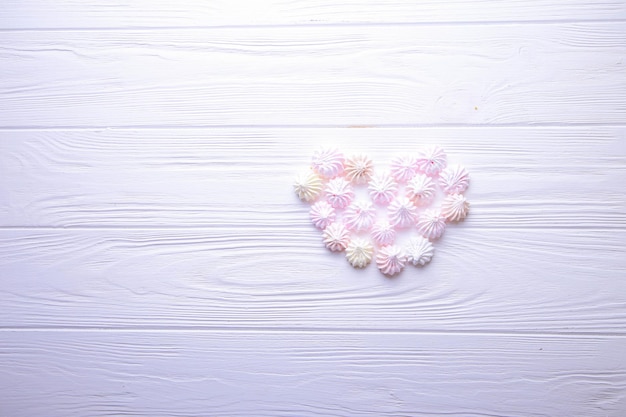 Photo heart of candy on a wooden background with place for text meringue heart
