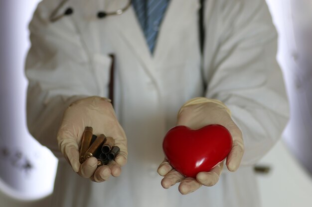 Foto cura del cuore e manica nel concetto di aiuto della mano del medico