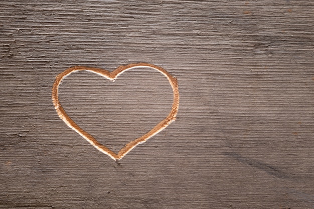 Foto cuore scolpito sulla tavola di legno.