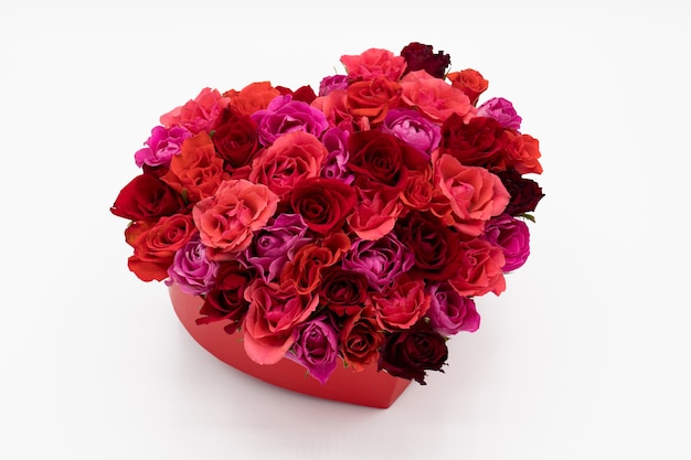 A heart of colorful red roses on white background