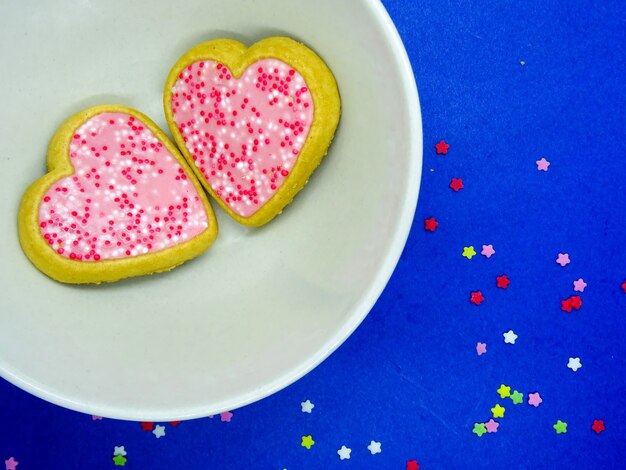 Heart cookies in a plate, blue background with copy space