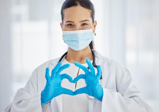 Heart covid and hands of a doctor with support love and help in healthcare at hospital Medicine insurance and portrait of a nurse with a face mask for virus care at a clinic and helping at work
