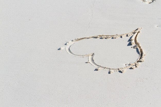 Heart drawing on the beach with wave.