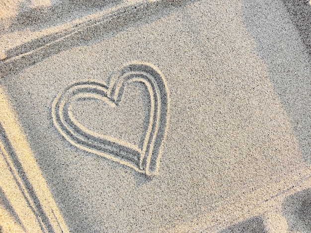 Heart drawn on sand in a frame concept of love and health top view closeup copy space