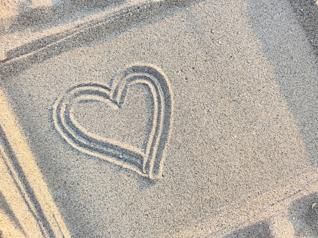 Heart drawn on the sand in a frame, copy space