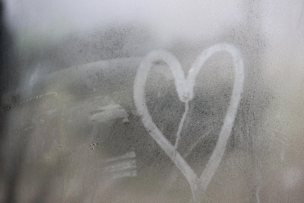 A heart drawn on a window with the word love on it