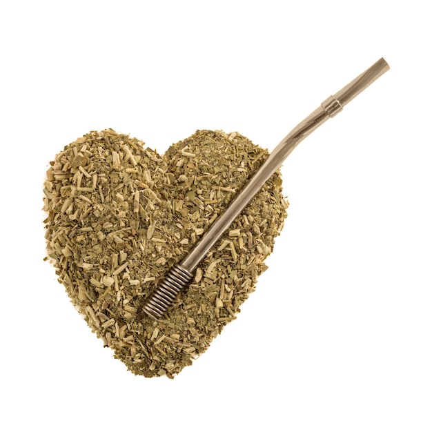 Heart of dry tea leaves Iron mate with a bombilla on white background isolate