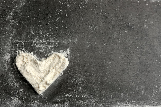 Photo heart of flour on gray background