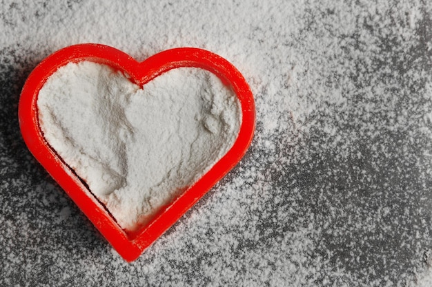 Heart of flour on gray background