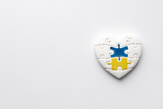 Heart in the form of puzzles with colors of the flag of Ukraine on a white background