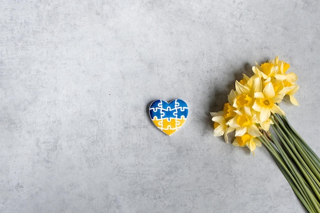 노란색 꽃이 있는 우크라이나 국기의 색상이 있는 퍼즐 형태의 심장