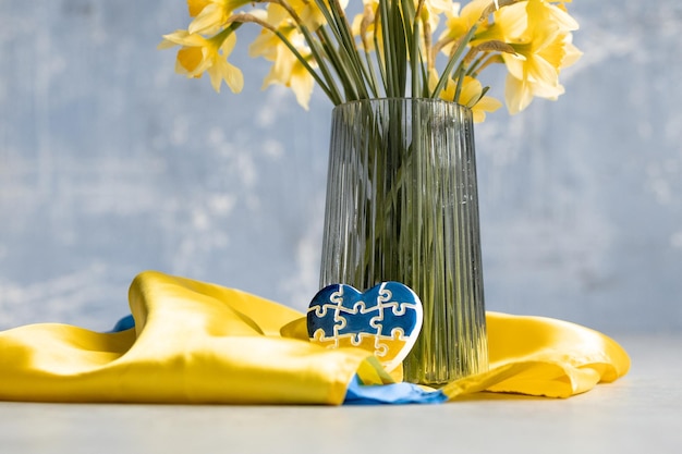 黄色い花とウクライナの旗の色でパズルの形でハート