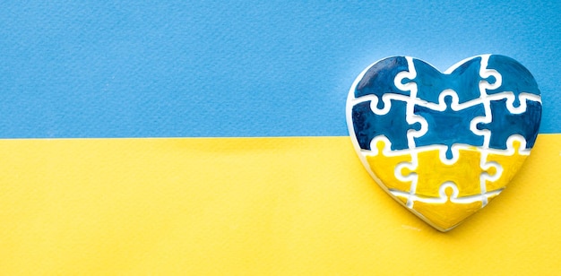 Heart in the form of puzzles with the colors of the flag of Ukraine