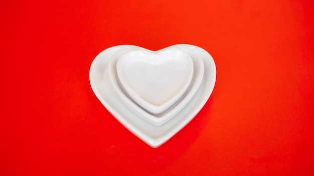 Heart form white plates on red