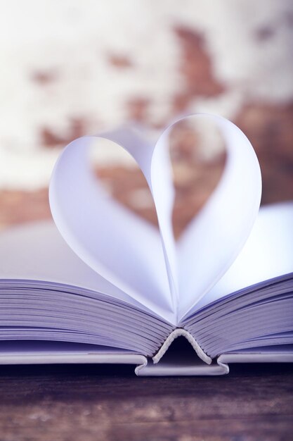 Heart from book pages on blurred background