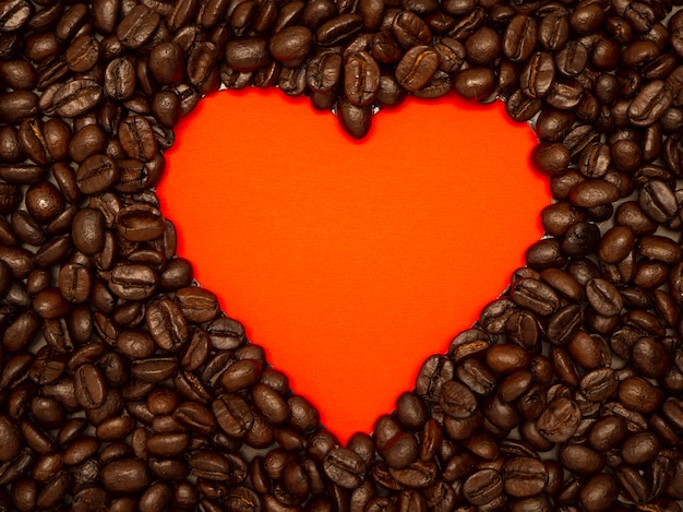 Heart from coffee beans on red