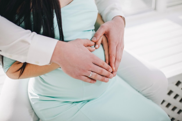 写真 妊娠中の女の子の胃の上の手からの心