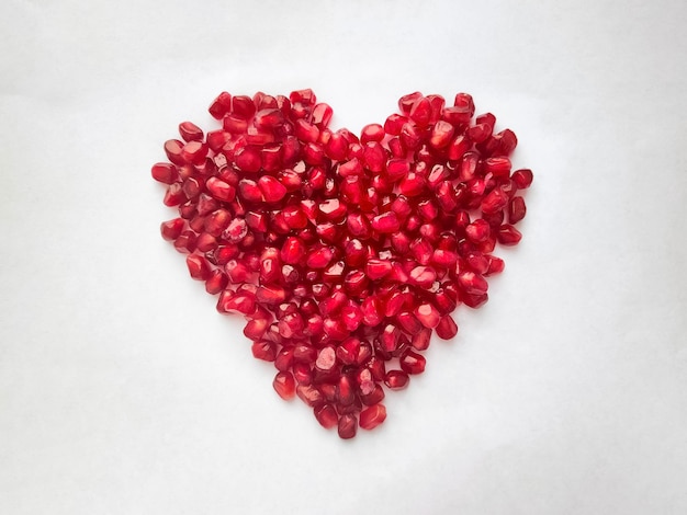 Heart from pomegranate seeds isolated on white background Heart shape High quality photo