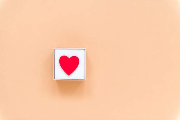 Heart in gift box on beige surface