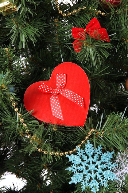 Foto cuore - confezione regalo su sfondo albero di natale, primo piano