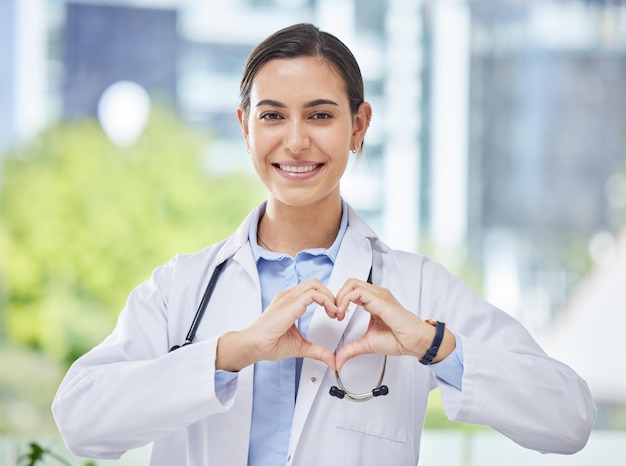 Photo heart hand and icon with happy doctor in medical clinic or hospital happy health and safety in the field of medicine and healthcare while love for her career job or work while ready to help