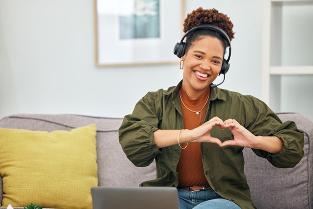 Heart in hands customer service and portrait of black woman on sofa for remote work business and startup Working from home emoji and female person with hand sign for love care and crm support
