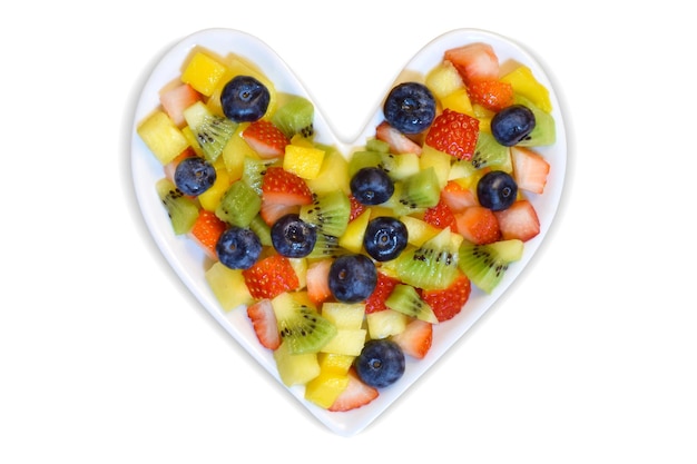 Photo heart health concept with fresh fruit on a heart shaped plate valentines day concept isolated