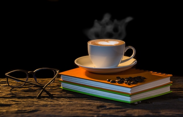 Foto caffè caldo cuore sul libro