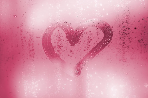 The heart is painted on the misted glass in winter image toned in viva magenta color of the  year