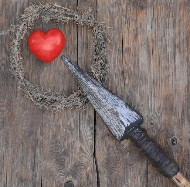 A heart is on a wooden table with a wreath and a heart on it.