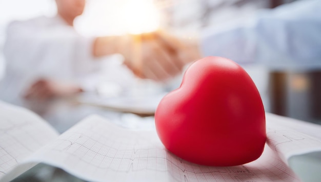 The heart lies on the table against the background of cardiologists in the background