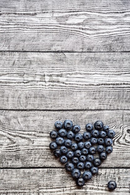 Heart made of blueberries on the wooden table