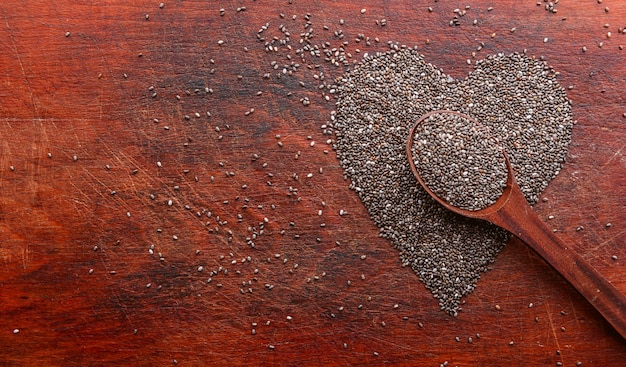 Heart made of chia seeds on a wooden table. concept of health and healthy eating