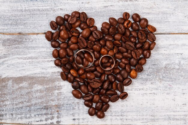 Heart made of coffee and wedding rings.