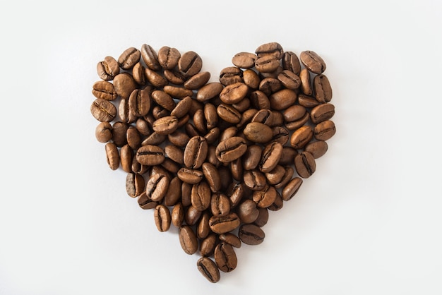 Heart made from coffee beans on a white surface