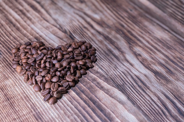 Foto cuore a base di chicchi di caffè su fondo di legno