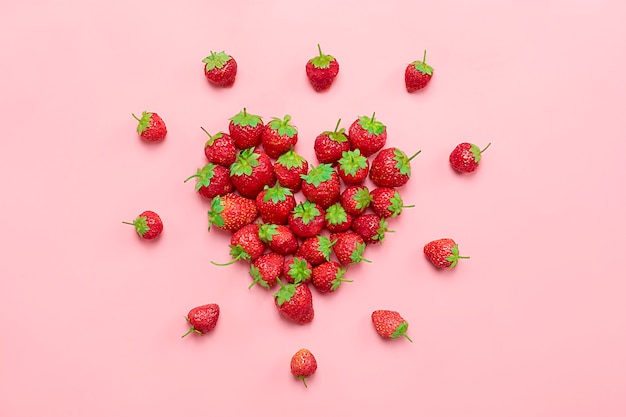 Cuore fatto da deluxe, fragola succosa naturale su sfondo rosa di tendenza