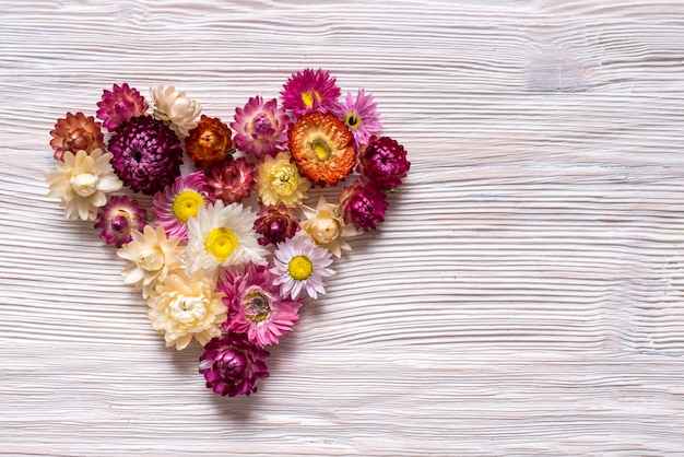 Photo heart made from flowers on wooden background