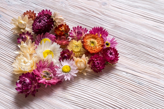 木製の背景に花から作られた心