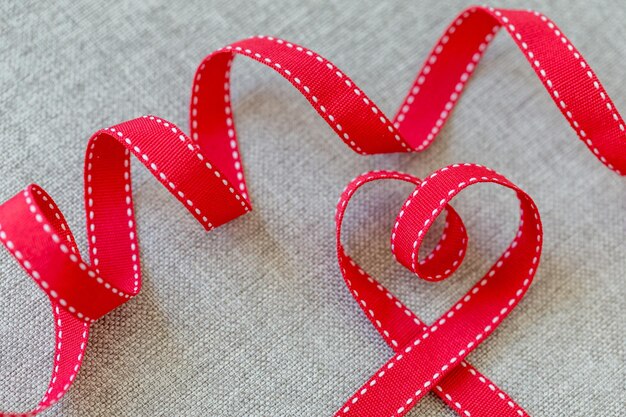 Photo heart made from red ribbon on linen fabric valentines day concept