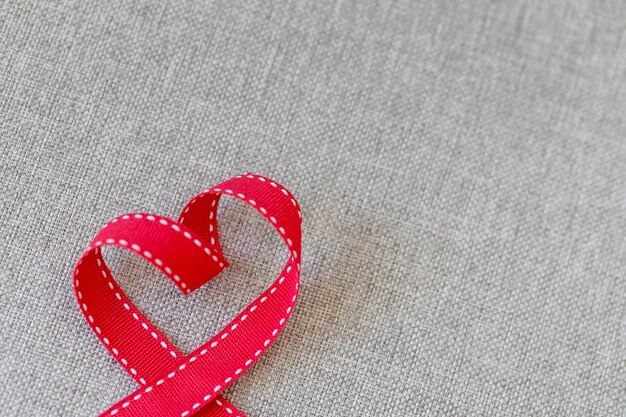 Photo heart made from red ribbon on linen textile with space for text valentines day concept