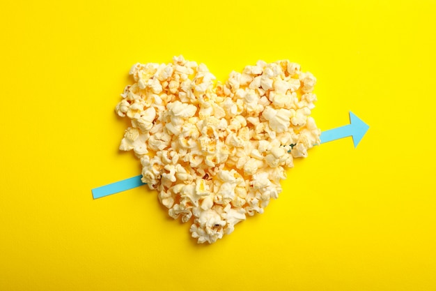 Heart made of popcorn on yellow space